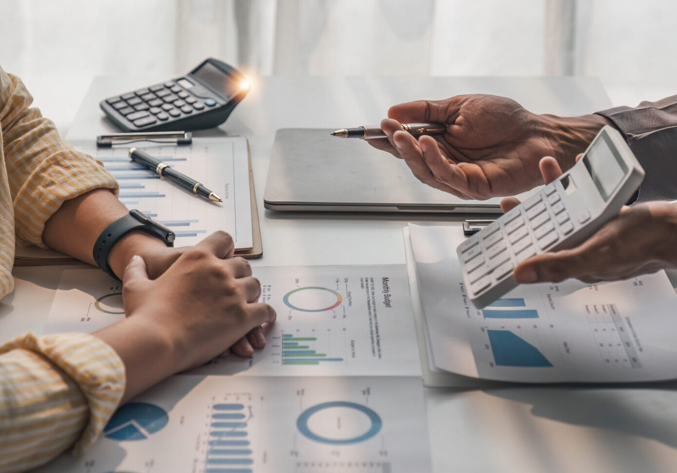 Two business people talk project strategy at office meeting room. Businessman discuss project planning with colleague at modern workplace while having conversation and advice on financial data report